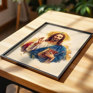 May include: A framed print featuring a watercolor-style illustration of a figure with long brown hair and a beard, wearing a white robe and blue cloak, holding a book in one hand and raising the other, set against a golden halo background.