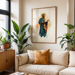 Op de afbeelding: Een ingelijste kunstdruk met een bebaarde figuur met een gouden halo, gekleed in een blauwgroene mantel en een okerkleurige omslagdoek, die een open boek vasthoudt. De illustratie gebruikt aquarelachtige wassingen op een lichte, neutrale achtergrond.