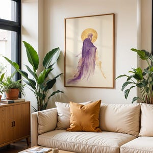 May include: A framed wall art print featuring a side profile illustration of a bearded figure in a flowing purple robe with a gold halo, set against a cream background, displayed in a wooden frame on a light-coloured wall above a sofa.
