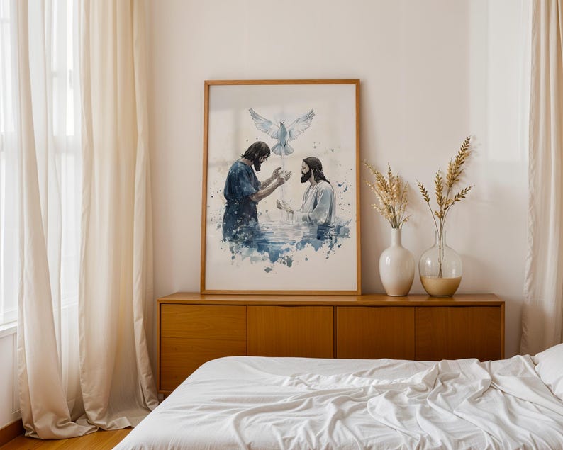 Peut inclure: Une impression d'art encadr&eacute;e de style aquarelle repr&eacute;sentant une sc&egrave;ne de bapt&ecirc;me avec deux personnages dans l'eau bleue, l'un les mains lev&eacute;es et l'autre lui faisant face, tandis qu'une colombe blanche descend sur fond blanc.