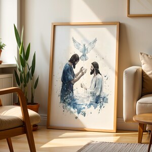 Peut inclure: Une impression encadr&eacute;e de style aquarelle repr&eacute;sentant une sc&egrave;ne de bapt&ecirc;me avec deux personnages dans l'eau, l'un en robe bleu fonc&eacute; et l'autre en robe blanche, avec une colombe blanche descendant, dans des tons de bleu, blanc et brun.