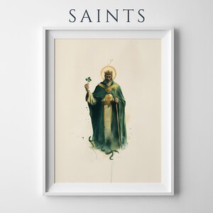 May include: A framed art print titled SAINTS featuring a bearded figure in a dark green robe and gold crown, holding a green shamrock in one hand and a staff in the other, with a golden halo above the head, set against a light cream background.