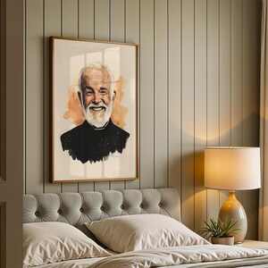 May include: A framed portrait print featuring a digital illustration of an older person with a white beard and hair, wearing a black shirt with a clerical collar, set against a soft orange watercolour-style background within a wooden frame.
