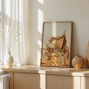 May include: A framed wall art print depicting a large wooden ship under construction in a desert landscape with figures in robes standing nearby. The artwork features warm beige and brown tones, showcasing the hull and scaffolding of the vessel.