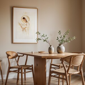Pode incluir: Uma mesa de jantar de madeira clara com quatro cadeiras de assento tran&ccedil;ado e encosto curvo. Dois vasos de cer&acirc;mica com ramos verdes est&atilde;o sobre a mesa. Uma gravura emoldurada de uma figura com halo segurando um p&aacute;ssaro na parede.