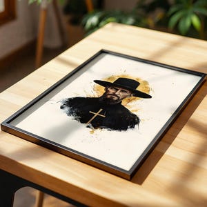 Puede incluir: Una l&aacute;mina art&iacute;stica enmarcada con una ilustraci&oacute;n al estilo acuarela de una persona barbuda que lleva un sombrero negro de ala ancha y una prenda oscura con un emblema de cruz visible, sobre un fondo circular amarillo dorado.