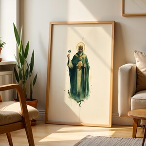 May include: A framed vertical wall art print featuring a bearded figure wearing a crown and a long dark green robe, holding a shamrock in one hand and a staff in the other, with a golden halo behind the head, set against a cream background.
