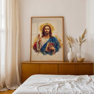 May include: A framed wall art print depicting a figure with long brown hair and a beard, wearing a white tunic and a blue cloak. The figure has a golden halo behind the head, holds a book in one hand, and raises the other in a gesture.