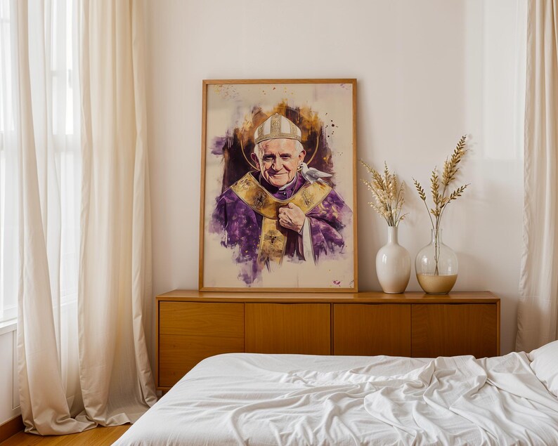 Peut inclure: Un portrait encadr&eacute; style aquarelle du Pape Jean-Paul II portant une mitre blanche et des v&ecirc;tements liturgiques violets avec des bordures dor&eacute;es. Une petite colombe blanche repose sur son &eacute;paule, sur un fond de taches de peinture violettes et dor&eacute;es.