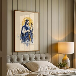 May include: A framed wall art print featuring a watercolour-style illustration of a figure with a crown playing a harp. The figure wears a blue and white robe, set against a circular yellow halo background with blue paint splatters and drips.