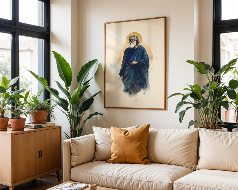 May include: A framed wall art print featuring a watercolor-style illustration of a bearded figure with long hair wearing a dark blue robe, positioned against a light cream background with a circular golden halo effect behind the head.