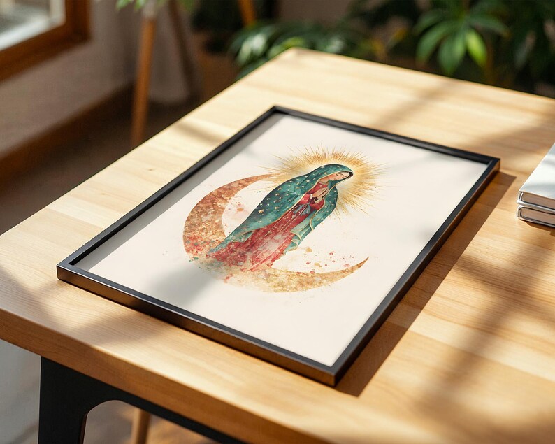 May include: A framed print featuring a watercolor illustration of the Virgin of Guadalupe standing on a crescent moon. The figure wears a teal mantle with gold stars over a red dress, surrounded by a golden sunburst halo on a cream background.