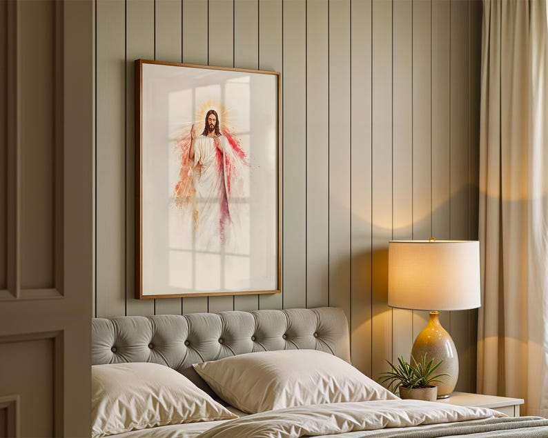 May include: A framed wall art print featuring a watercolor-style illustration of Jesus Christ with a glowing halo, wearing white robes with red accents, displayed in a wooden frame on a vertical paneled wall above a tufted gray headboard.