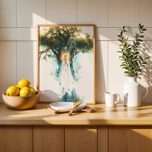 May include: A framed watercolour-style print depicting a figure in a white robe and crown standing before a large tree, displayed on a counter with a wooden bowl of yellow lemons, a white plate, a wooden spoon, a white mug, and a white vase.