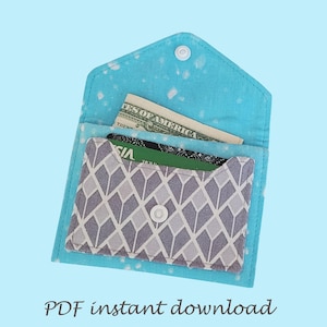 May include: A handmade fabric wallet with a light blue exterior and a geometric patterned interior. The wallet is open, revealing a dollar bill and credit cards. The text "PDF instant download" is at the bottom.