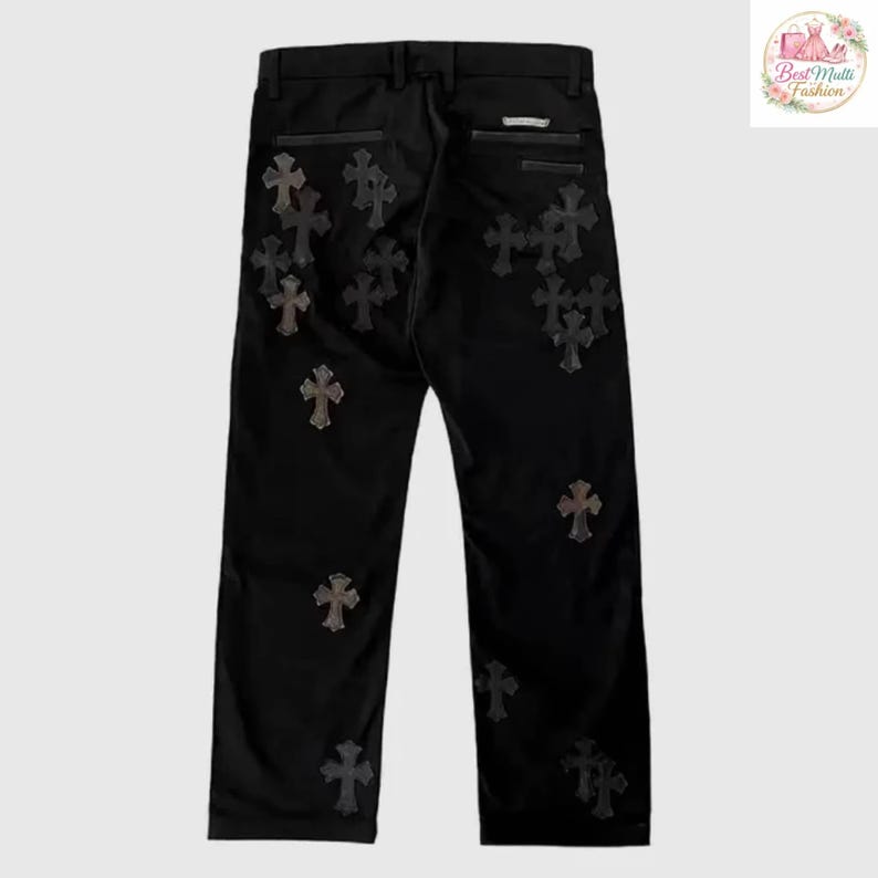 May include: Black pants with multiple cross-shaped embellishments in a darker tone. The pants have a classic five-pocket design and a straight leg cut. The crosses are evenly distributed across the front and back of the pants.