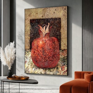 May include: A framed artwork showing a detailed red pomegranate with ornate patterns, set against a textured, golden-brown background. The artwork is displayed in a modern living space. The pomegranate is the focal point of the artwork.