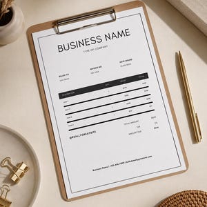 May include: A clipboard with a printed invoice. The invoice includes the business name, invoice number, date, and itemized descriptions with prices. A gold pen rests beside the clipboard, and gold binder clips are on a plate.