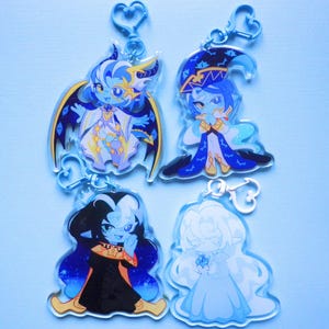 Puede incluir: Cuatro llaveros de acrílico transparente con personajes de estilo anime chibi. Arriba a la izquierda una figura alada, arriba a la derecha un mago con sombrero azul, abajo a la izquierda un personaje de pelo oscuro y abajo a la derecha una figura blanca.