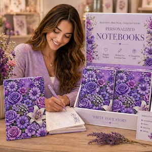 Puede incluir: Exhibición de cuadernos personalizados con diseños florales en tonos morados. Los cuadernos están en una caja expositora blanca con el texto "PERSONALIZED NOTEBOOKS". Una mujer escribe en un cuaderno con una cubierta floral.