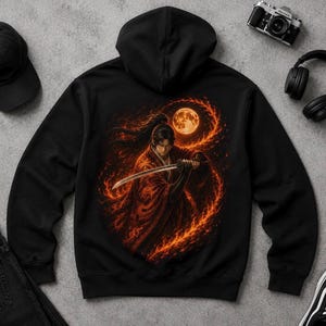 Könnte beinhalten: Schwarzer Kapuzenpullover mit einer detaillierten Illustration eines Samurai, der ein Schwert hält, vor einem feurigen, orange-roten Hintergrund mit Vollmond. Das Design befindet sich mittig auf der Vorderseite des Kapuzenpullovers.
