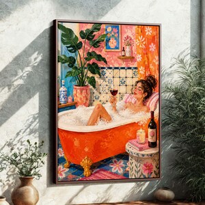 Può includere: Una stampa artistica incorniciata raffigura una persona che si rilassa in una vasca da bagno con bolle, con un bicchiere di vino rosso. La vasca arancione con piedini a zampa è piena di bolle. Arredamento floreale, pianta in vaso e candela.