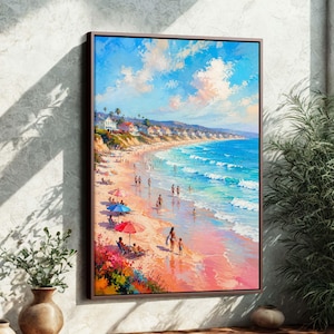 May include: A framed beach scene painting. The artwork depicts a sunny beach with people, colorful umbrellas, and houses along the coastline. The sky is blue with fluffy clouds, and the ocean is a vibrant turquoise.