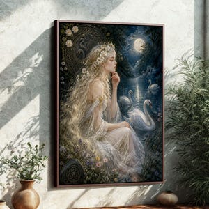 May include: A framed art print depicts a woman with long blonde hair, wearing a white dress and floral crown, seated near a lake with swans under a full moon. The artwork has a mystical, ethereal theme.