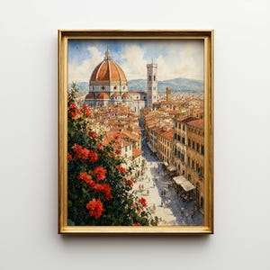 May include: Framed watercolor painting of Florence, Italy, featuring the Duomo and Giotto's Campanile. The artwork showcases a cityscape with red-tiled roofs, a bustling street, and vibrant red flowers in the foreground. The frame is gold.