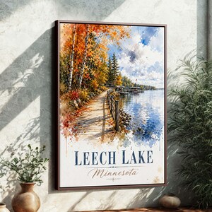 Könnte beinhalten: Ein gerahmter Aquarelldruck von Leech Lake, Minnesota. Das Kunstwerk zeigt einen Holzsteg am See, umgeben von Bäumen mit leuchtendem Herbstlaub. Der Himmel ist blau mit flauschigen Wolken, und der See spiegelt die Farben der Szene wider.