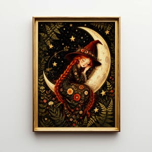 May include: A framed print featuring a sleeping witch with long red braids, wearing a black dress with floral accents and a red hat, resting on a crescent moon. The background is a starry night with gold stars and foliage.