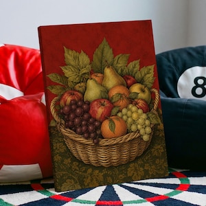 Op de afbeelding: Een ingelijste kunstdruk met een gevlochten rieten mand gevuld met diverse vruchten, waaronder rode en groene druiven, appels, peren en sinaasappels, genesteld tussen groene bladeren tegen een dieprode achtergrond en een donkergroene basis.