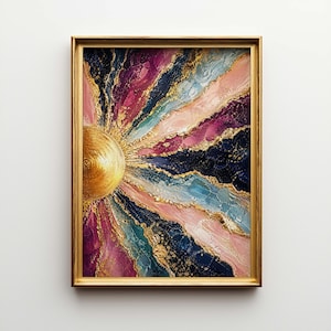 May include: Abstract art print in a gold frame. The artwork features a golden sunburst design with vibrant colors including pink, purple, blue, and navy, accented with gold details. The framed art is displayed against a white background.