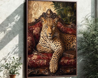 May include: A framed art print featuring a regal leopard resting on a red ornate sofa. The leopard has a spotted coat and is gazing directly at the viewer. The background includes a gold patterned wall and lush greenery.