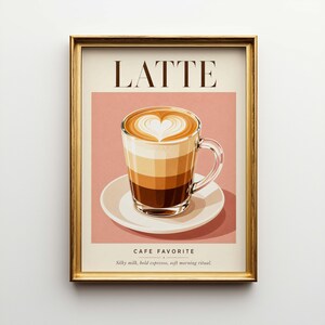 May include: Framed art print featuring a latte with a heart-shaped design in the foam. The print includes the word "LATTE" at the top and "CAFE FAVORITE" at the bottom, with text below that reads "Silky milk, bold espresso, soft morning ritual."