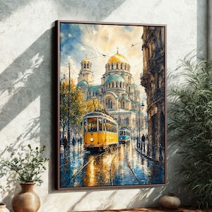 May include: A framed art print depicts a European city scene with a yellow tram on wet cobblestone streets. The artwork features a large cathedral with gold domes and blue accents, and a cloudy sky.