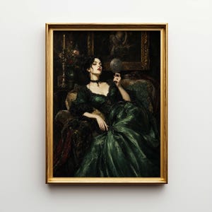 May include: A framed vintage portrait of a woman in a dark green gown, seated and holding a mirror. The gold frame surrounds the artwork, which features a candle and floral arrangement in the background. The woman has dark hair and is wearing a black choker.