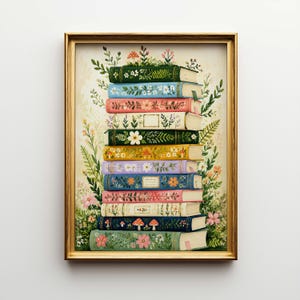 May include: A framed print featuring a stack of colorful books adorned with floral and botanical designs. The books are in various colors, including green, blue, pink, and yellow, with detailed illustrations of flowers and foliage. The artwork is set against a cream-colored background.