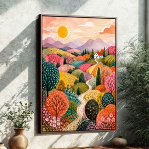 Op de afbeelding: Een ingelijste aquarel schilderij van een kleurrijk landschap. Het kunstwerk toont glooiende heuvels met bomen in tinten roze, oranje, geel en groen. Een kronkelend pad leidt naar een wit huis met een rood dak onder een heldere gele zon.