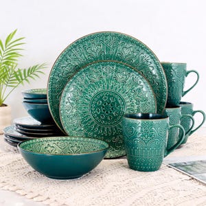 Puede incluir: Un juego de vajilla de cerámica turquesa con platos, cuencos y tazas. Los platos y tazas tienen un diseño floral en relieve detallado. El juego incluye platos y cuencos de varios tamaños, ideal para una experiencia gastronómica completa.