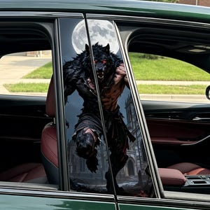May include: Car window decals featuring a menacing werewolf with glowing red eyes, set against a full moon and a gothic cathedral. The artwork is detailed and dramatic, creating a striking visual effect on the vehicle's windows.