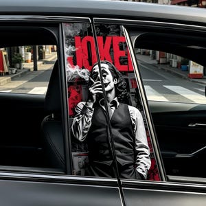 May include: Car window sticker showing a black and white image of a person smoking, with the word "JOKE" in red. The background features red and white posters. The image is set against a car window.