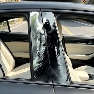 Op de afbeelding: Autoraamstijlstickers met een gesplitst ontwerp van een engel en een demon. De engelenkant is wit met een grote vleugel, terwijl de demonenkant zwart is met een figuur met capuchon. De stickers zijn aangebracht op een zwarte auto.