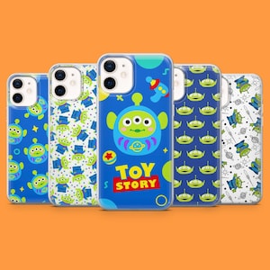 May include: A collection of five phone cases featuring designs from the movie Toy Story. The cases have a blue background with images of the Little Green Men, a rocket, and the words "TOY STORY". The cases are made of a clear, glossy material.