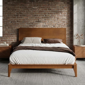 May include: A wooden bed frame with a tall headboard, featuring a white duvet, a dark brown knit throw blanket, and two matching wooden nightstands. The bed is dressed with one light gray pillow and one dark brown pillow, set on a gray rug.