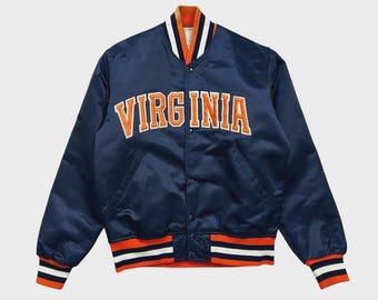 May include: A navy blue satin varsity jacket featuring the word VIRGINIA in orange block lettering across the chest. The jacket has a snap-button front closure, long sleeves, and ribbed cuffs and hem with orange, white, and navy blue stripes.