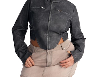 May include: A charcoal gray cropped jacket with a distressed finish, featuring a mandarin collar with two snap buttons, a full-length front zipper, and two horizontal zippered chest pockets, paired with a light tan denim mini skirt.