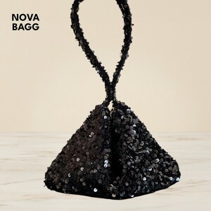 Peut inclure: Un sac à main noir à sequins de forme triangulaire avec une poignée en boucle. Le sac est recouvert de sequins noirs brillants, reflétant la lumière. Le texte "NOVA BAGG" est dans le coin supérieur gauche.