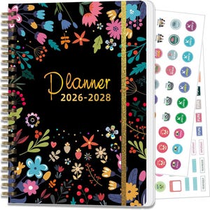 May include: A spiral-bound planner with a black cover adorned with colorful floral designs. The cover features the word "Planner" in gold script, along with the years 2026-2028. Includes sticker sheets with various icons and labels for organization.
