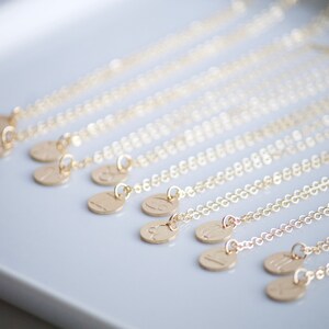 May include: A set of gold necklaces with small round pendants featuring different zodiac signs. Each necklace is delicate and features a simple chain.